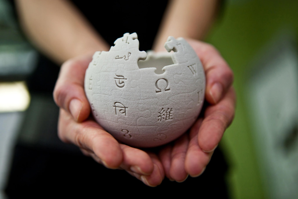 Wikipedia en un miniglobo en la mano